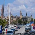 City street with cars, marina, and historic architecture