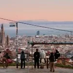People watch the barcelona cityscape and sagrada familia at sunset