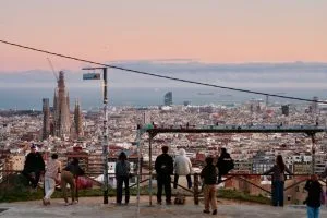 People watch the barcelona cityscape and sagrada familia at sunset
