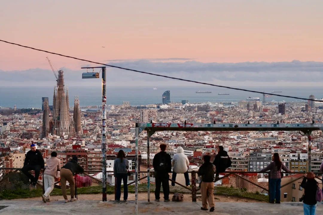 People watch the barcelona cityscape and sagrada familia at sunset