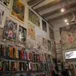 Art prints and books displayed on a stone wall