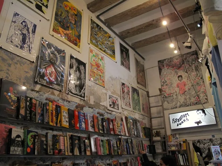 Art prints and books displayed on a stone wall