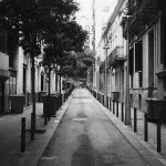 Narrow street lined with buildings and trees