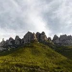 the mountains are covered in green vegetation under a cloudy sky