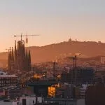 A view of a city at sunset with a mountain in the background