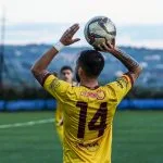 A man holding a soccer ball on top of a field