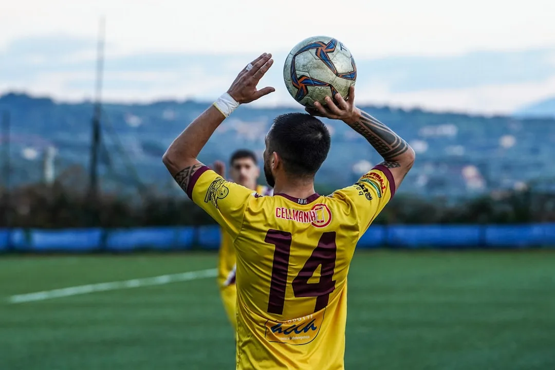 A man holding a soccer ball on top of a field
