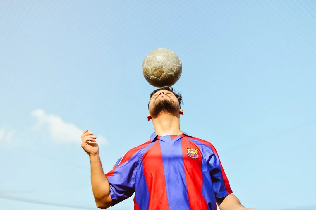 A man is balancing a soccer ball on his head
