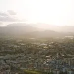 A bird's eye view of a city with mountains in the background