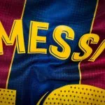 Yellow lettering reading MESS on a blue and red patterned sports jersey