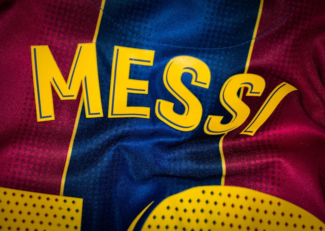 Yellow lettering reading MESS on a blue and red patterned sports jersey