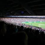 people watching football at stadium during daytime
