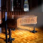 a grand piano sitting on a wooden floor