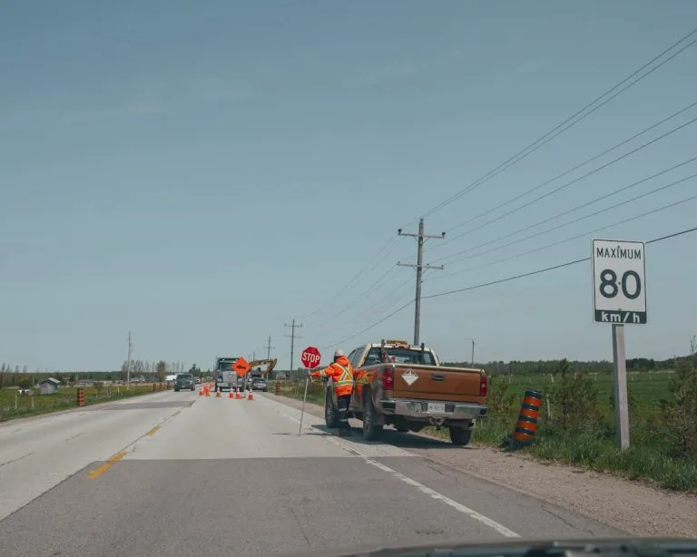 Road construction worker with stop sign and truck
