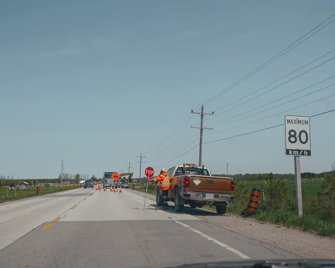 Road construction worker with stop sign and truck