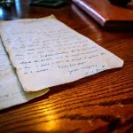 An old handwritten letter rests on a wooden table