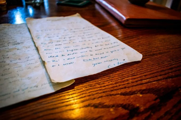 An old handwritten letter rests on a wooden table
