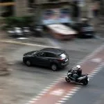 a car and a motorcycle driving down a street