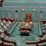 Empty parliamentary chamber with rows of seats