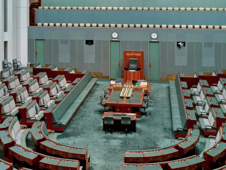 Empty parliamentary chamber with rows of seats