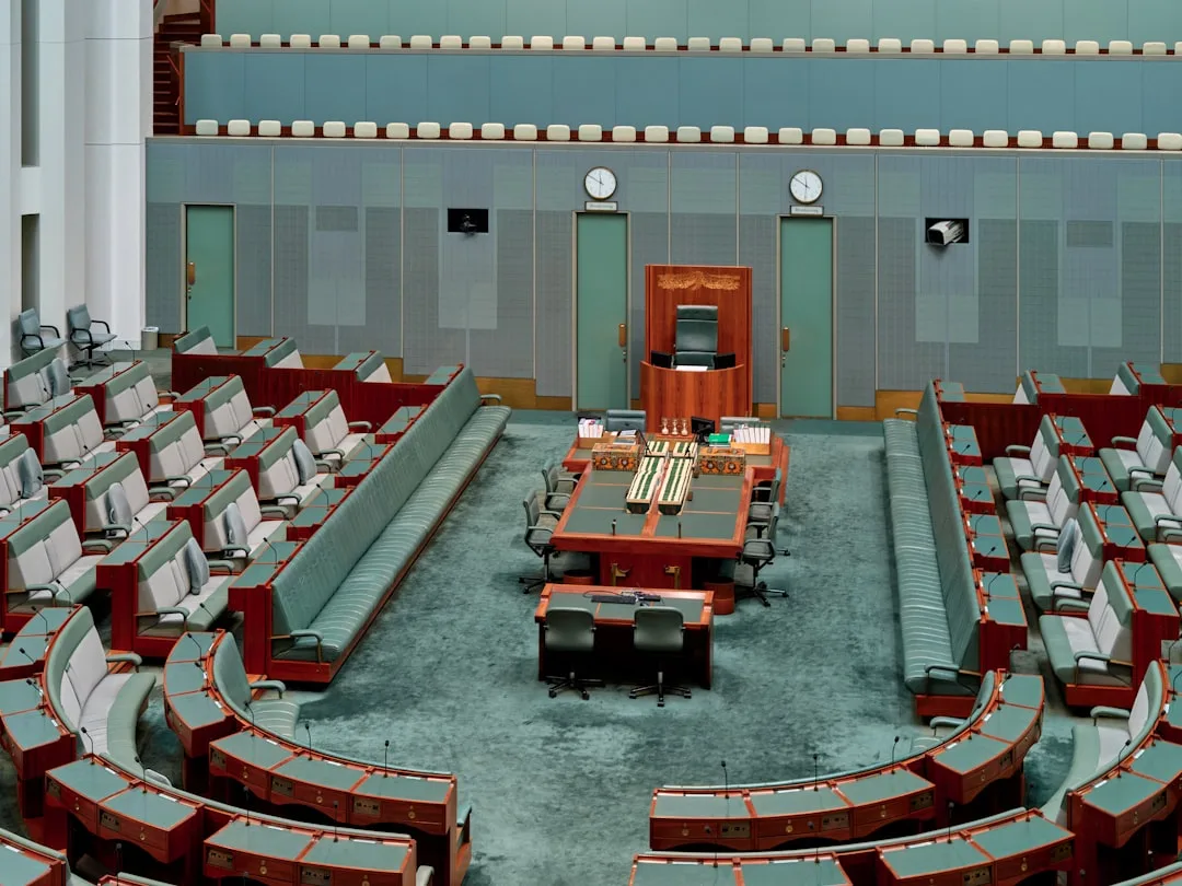 Empty parliamentary chamber with rows of seats