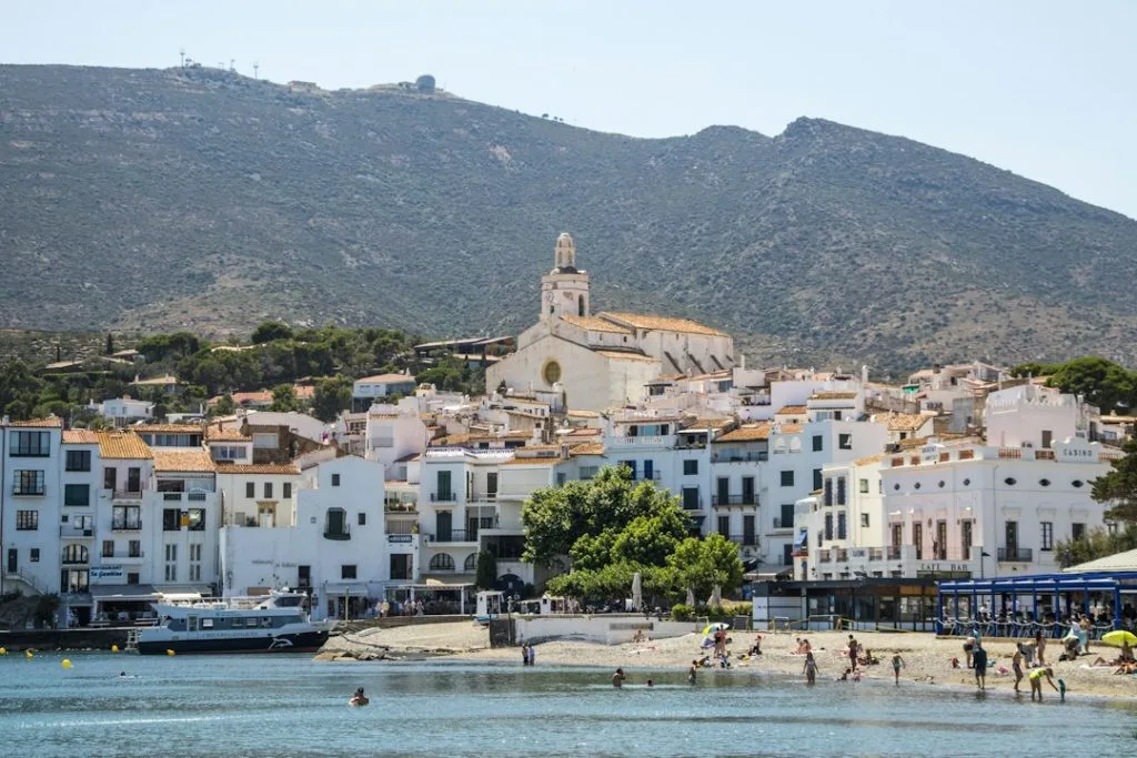 Coastal town with church and mountain backdrop
