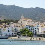 Coastal town with church and mountain backdrop